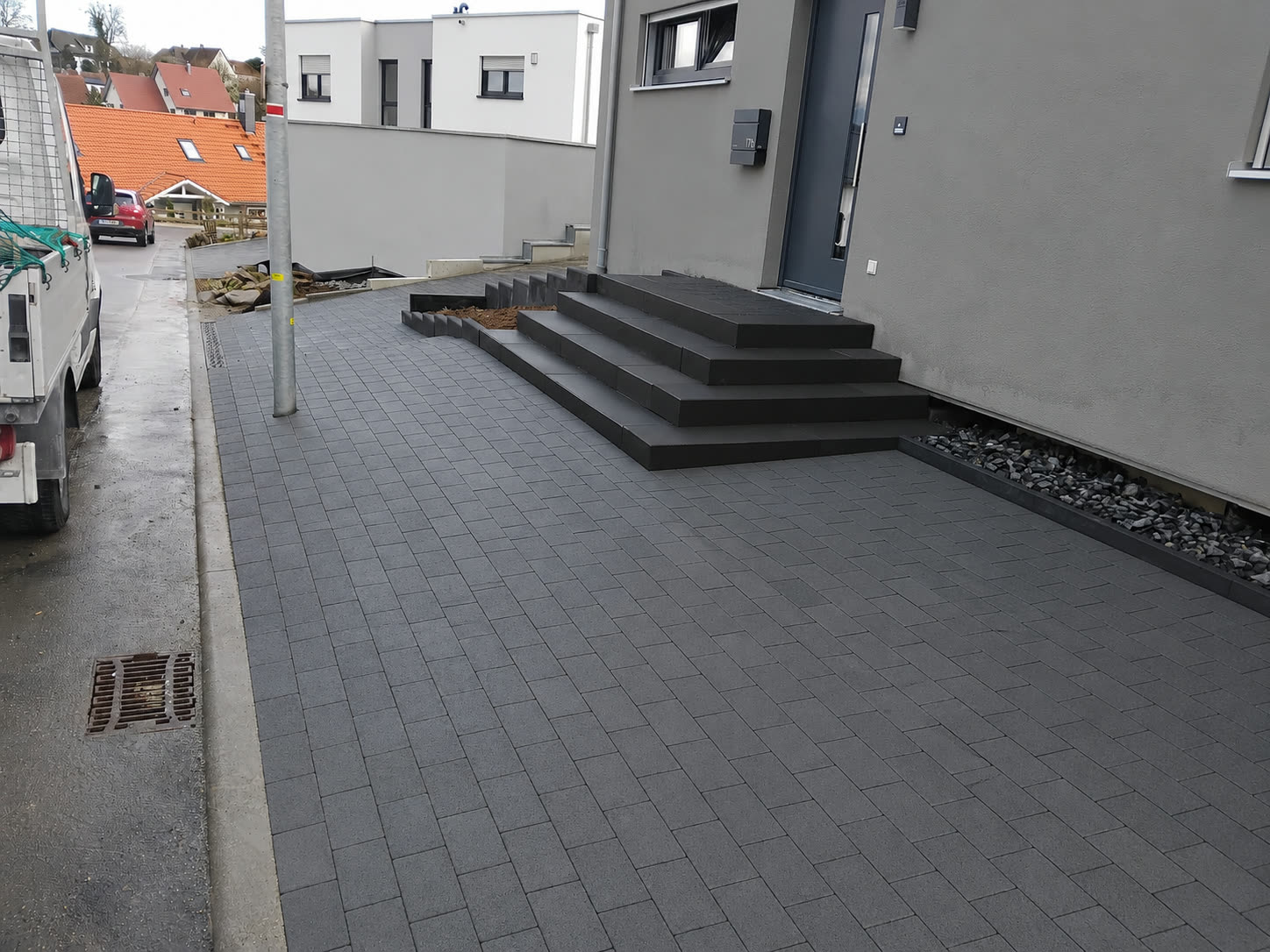 Dunkle Pflasterung mit Naturstein-Treppen am Neubau in Sachsenheim